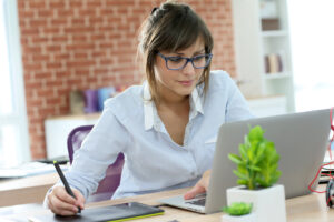 Junge Frau arbeitet mit PC und Tablet. Foto: © goodluz –stock.adobe_.com