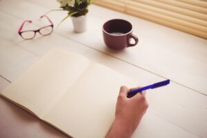 Ein Mensch schreibt in ein Notizbuch. Foto: © WavebreakMediaMicro – stock.adobe.com