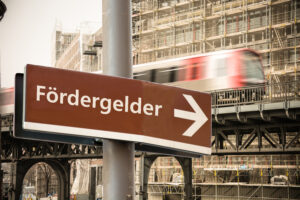 Das Bild zeigt ein Schild mit dem Wort Fördergelder und einem Pfeil. Foto: © Thomas Reimer/AdobeStock